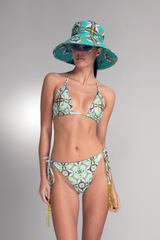 Woman wearing a patterned bikini and matching hat on a gray background